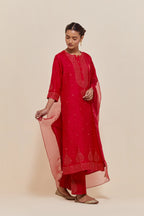 Red silk straight kurta set with hand-embroidered sequins at the neck, borders running along the hem and sleeve edges, and scattered gold sequins embellishments all-over.