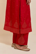Red silk straight kurta set with hand-embroidered sequins at the neck, borders running along the hem and sleeve edges, and scattered gold sequins embellishments all-over.