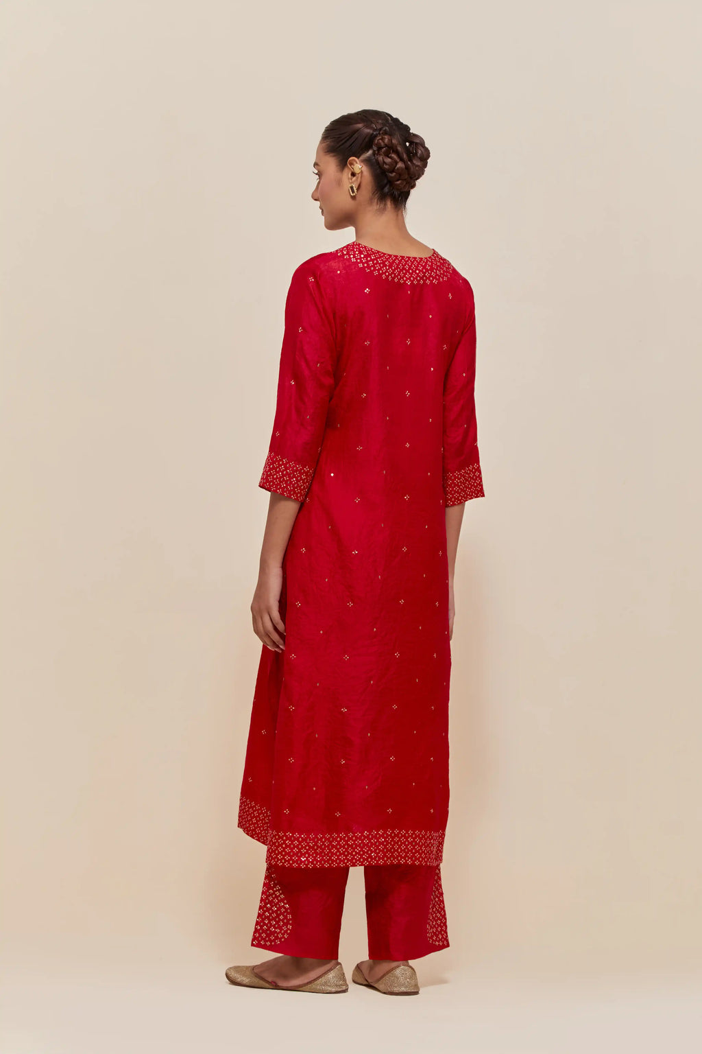 Red silk straight kurta set with hand-embroidered sequins at the neck, hem and sleeves, highlighted with scattered gold sequins embellishments all-over.