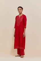 Red silk straight kurta set with hand-embroidered sequins at the neck, hem and sleeves, highlighted with scattered gold sequins embellishments all-over.