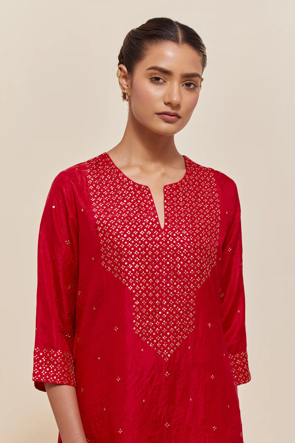 Red silk straight kurta set with hand-embroidered sequins at the neck, hem and sleeves, highlighted with scattered gold sequins embellishments all-over.