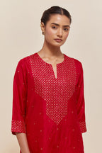 Red silk straight kurta set with hand-embroidered sequins at the neck, hem and sleeves, highlighted with scattered gold sequins embellishments all-over.
