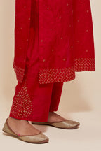 Red silk straight kurta set with hand-embroidered sequins at the neck, hem and sleeves, highlighted with scattered gold sequins embellishments all-over.