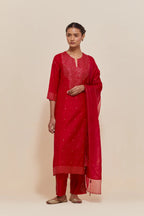 Red silk straight kurta set with hand-embroidered sequins at the neck, hem and sleeves, highlighted with scattered gold sequins embellishments all-over.