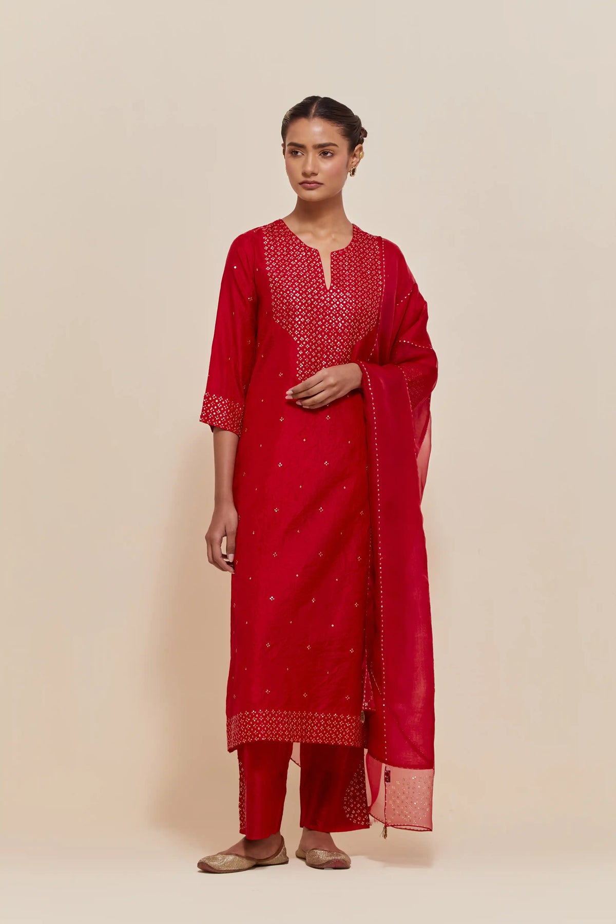 Red silk straight kurta set with hand-embroidered sequins at the neck, hem and sleeves, highlighted with scattered gold sequins embellishments all-over.