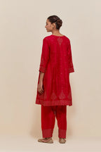 Red silk short kalidar kurta set, with hand embroidered sequins at neck, hem and sleeve edges, highlighted with scattered gold sequins embellishments all-over.
