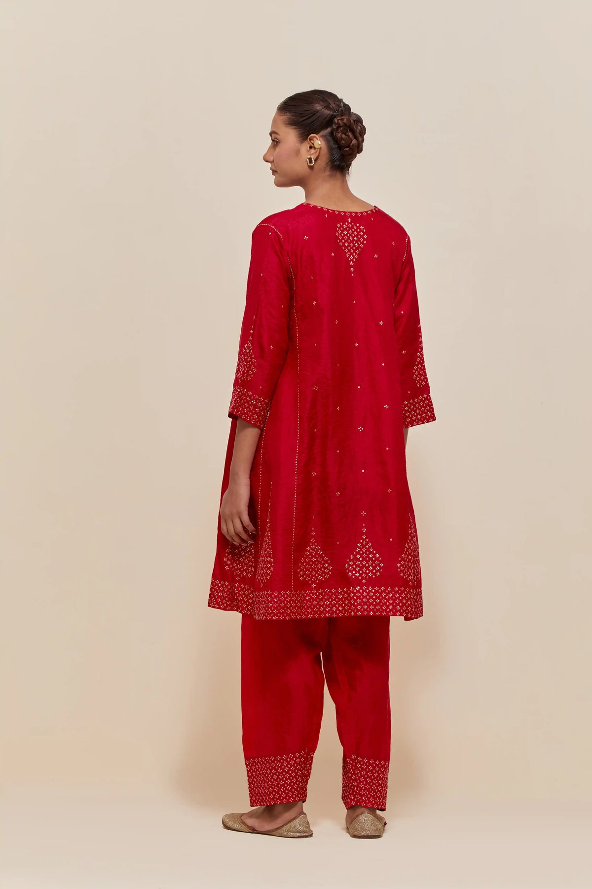 Red silk short kalidar kurta set, with hand embroidered sequins at neck, hem and sleeve edges, highlighted with scattered gold sequins embellishments all-over.