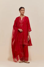 Red silk short kalidar kurta set, with hand embroidered sequins at neck, hem and sleeve edges, highlighted with scattered gold sequins embellishments all-over.
