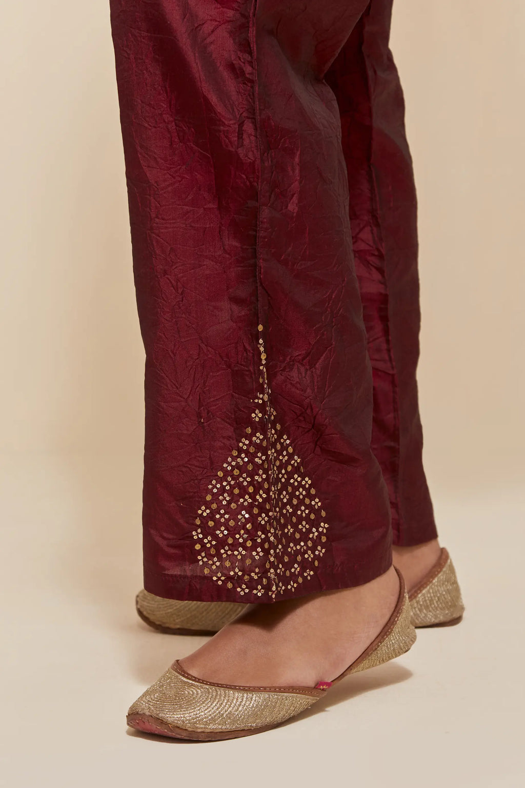 Maroon Silk pants with hand embroidered leaf motifs with delicate sequins work at hem.