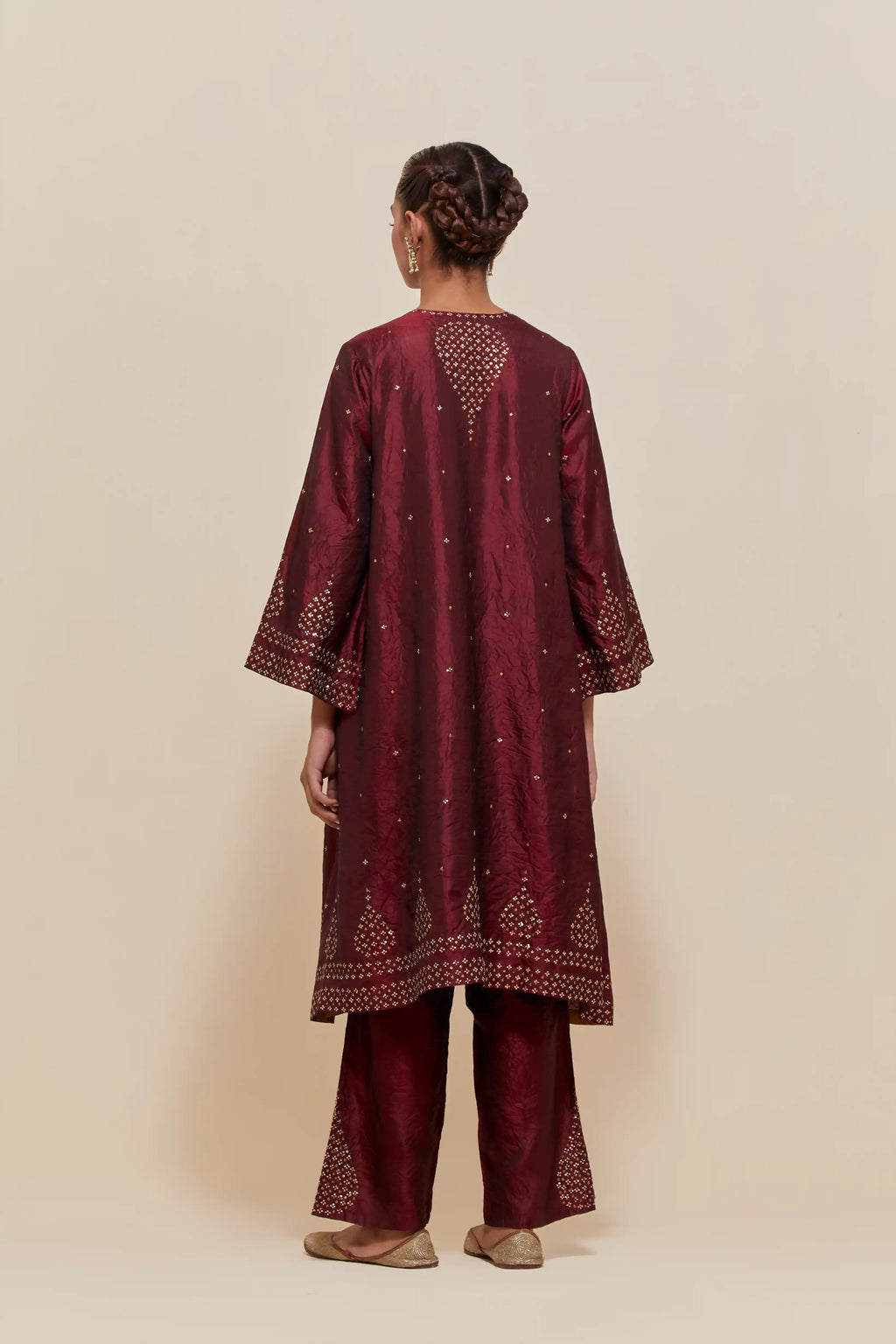 Maroon silk A-line short kurta set with hand-embroidered sequins at the neck, borders running along the hem and sleeve edges, and scattered gold sequin embellishments all-over.