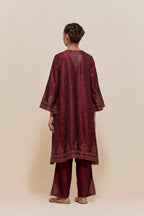 Maroon silk A-line short kurta set with hand-embroidered sequins at the neck, borders running along the hem and sleeve edges, and scattered gold sequin embellishments all-over.