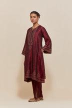 Maroon silk A-line short kurta set with hand-embroidered sequins at the neck, borders running along the hem and sleeve edges, and scattered gold sequin embellishments all-over.