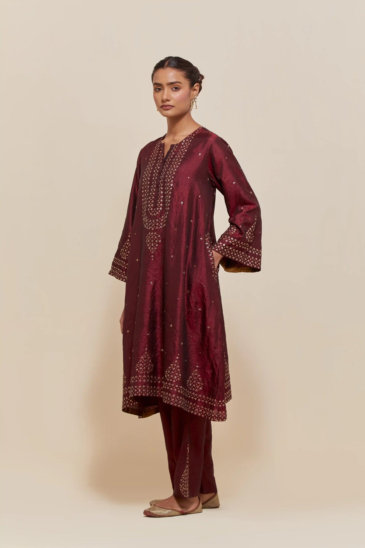 Maroon silk A-line short kurta set with hand-embroidered sequins at the neck, borders running along the hem and sleeve edges, and scattered gold sequin embellishments all-over.
