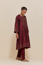 Maroon silk A-line short kurta set with hand-embroidered sequins at the neck, borders running along the hem and sleeve edges, and scattered gold sequin embellishments all-over.