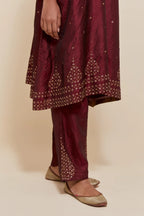 Maroon silk A-line short kurta set with hand-embroidered sequins at the neck, borders running along the hem and sleeve edges, and scattered gold sequin embellishments all-over.