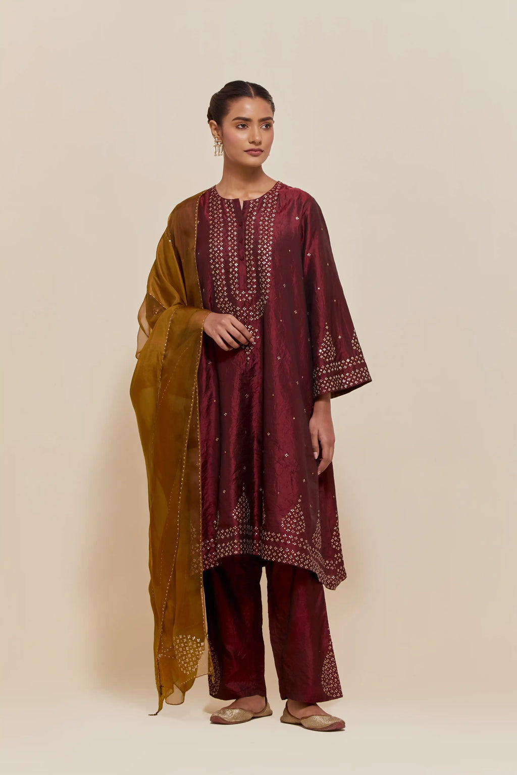 Maroon silk A-line short kurta set with hand-embroidered sequins at the neck, borders running along the hem and sleeve edges, and scattered gold sequin embellishments all-over.