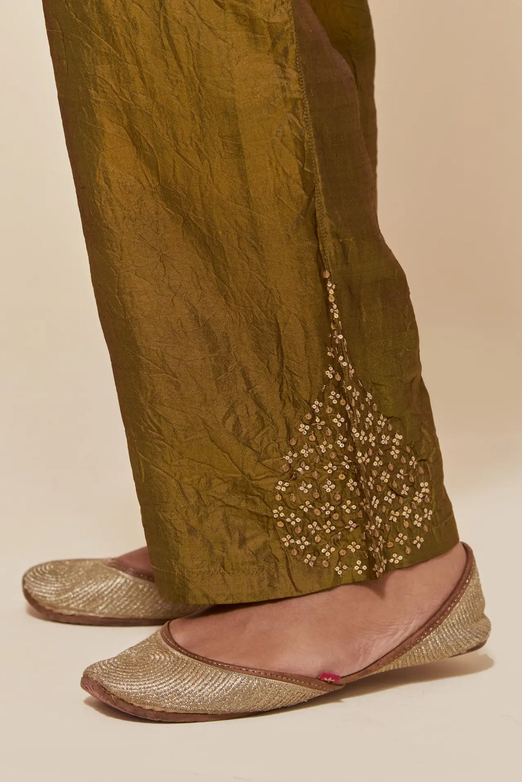 Olive Silk pants with hand embroidered leaf motifs with delicate sequins work at hem.
