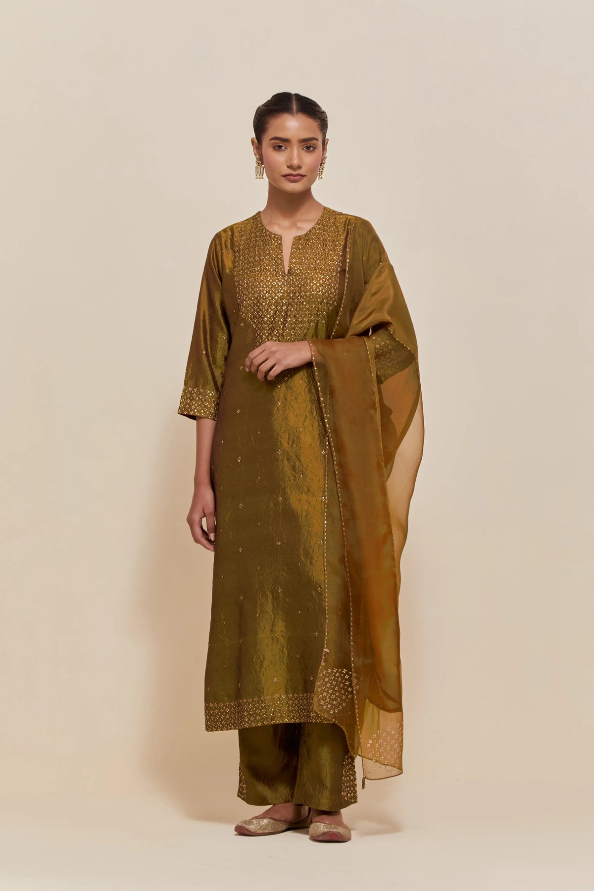 Olive silk straight kurta set with hand-embroidered sequins at the neck, hem and sleeves, highlighted with scattered gold sequins embellishments all-over.