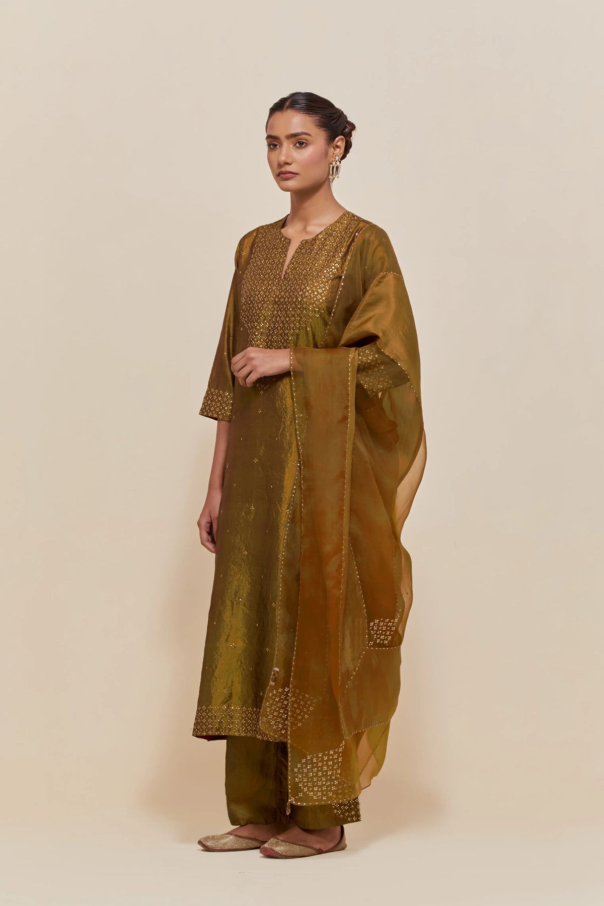 Olive silk straight kurta set with hand-embroidered sequins at the neck, hem and sleeves, highlighted with scattered gold sequins embellishments all-over.