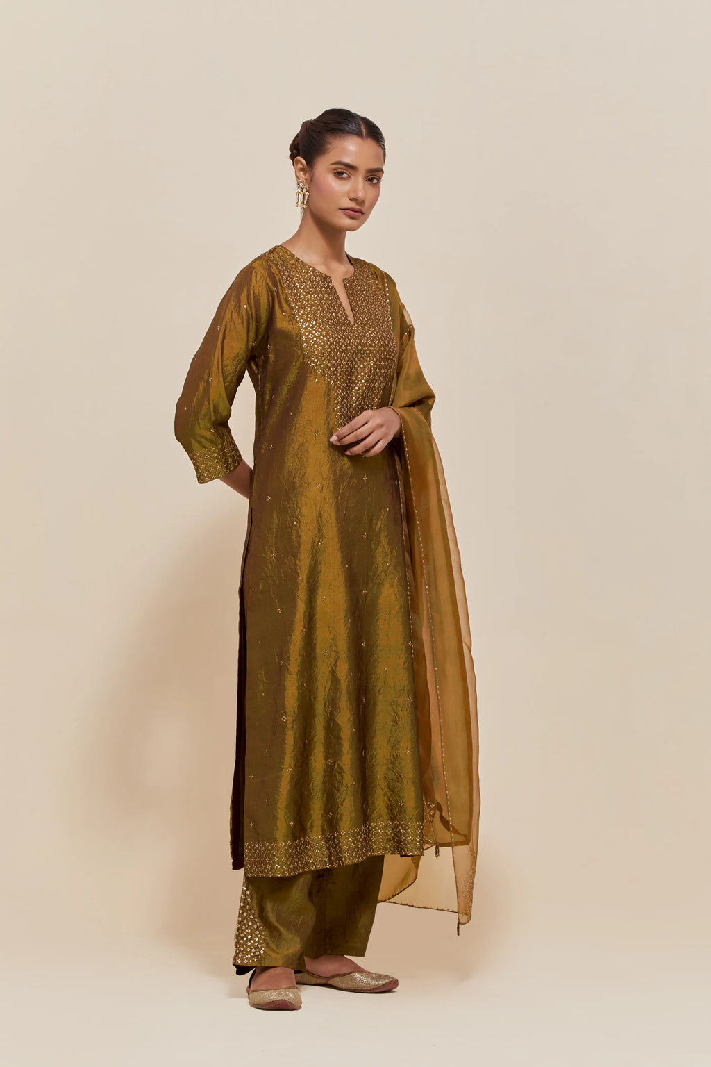 Olive silk straight kurta set with hand-embroidered sequins at the neck, hem and sleeves, highlighted with scattered gold sequins embellishments all-over.