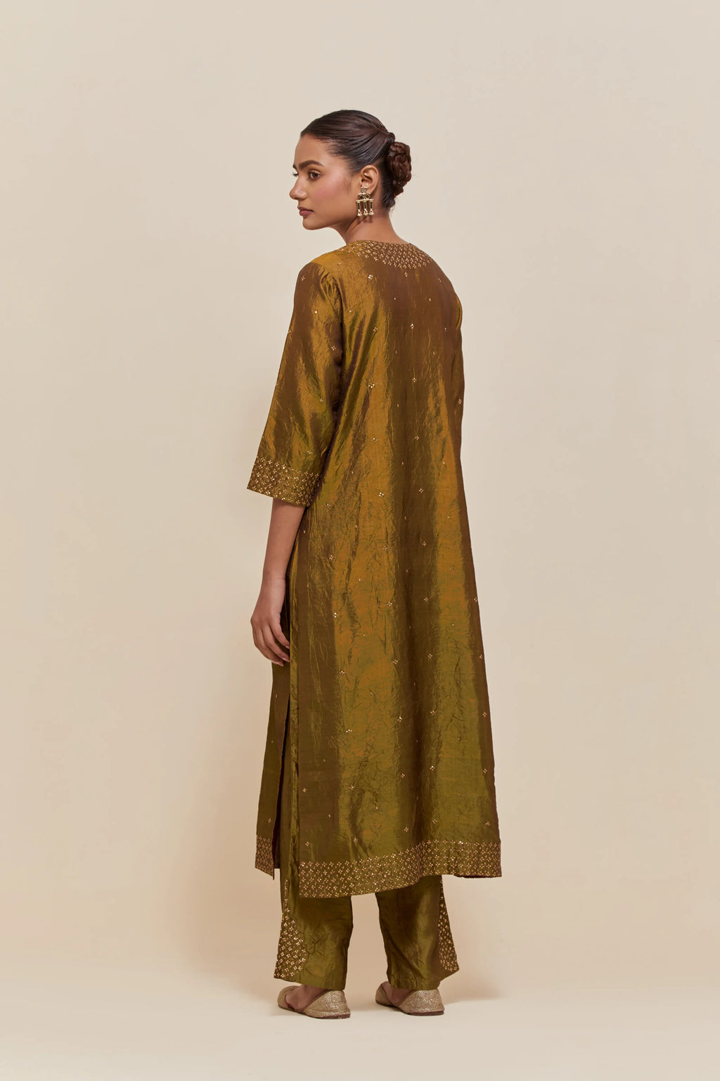 Olive silk straight kurta set with hand-embroidered sequins at the neck, hem and sleeves, highlighted with scattered gold sequins embellishments all-over.