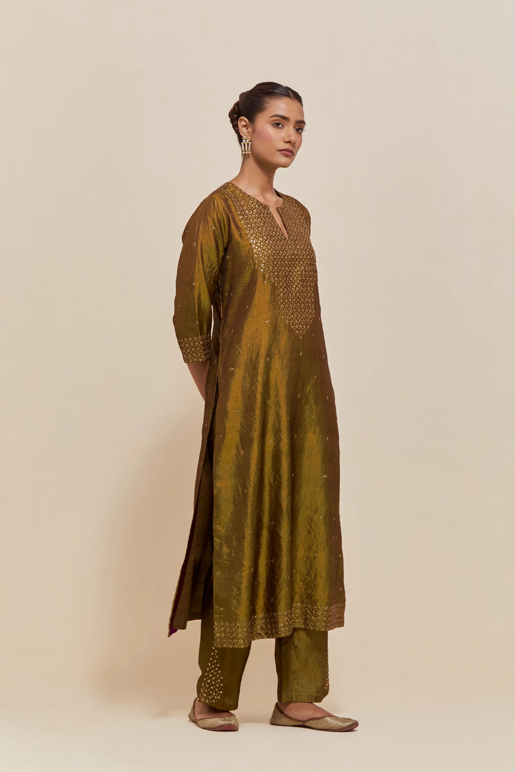 Olive silk straight kurta set with hand-embroidered sequins at the neck, hem and sleeves, highlighted with scattered gold sequins embellishments all-over.
