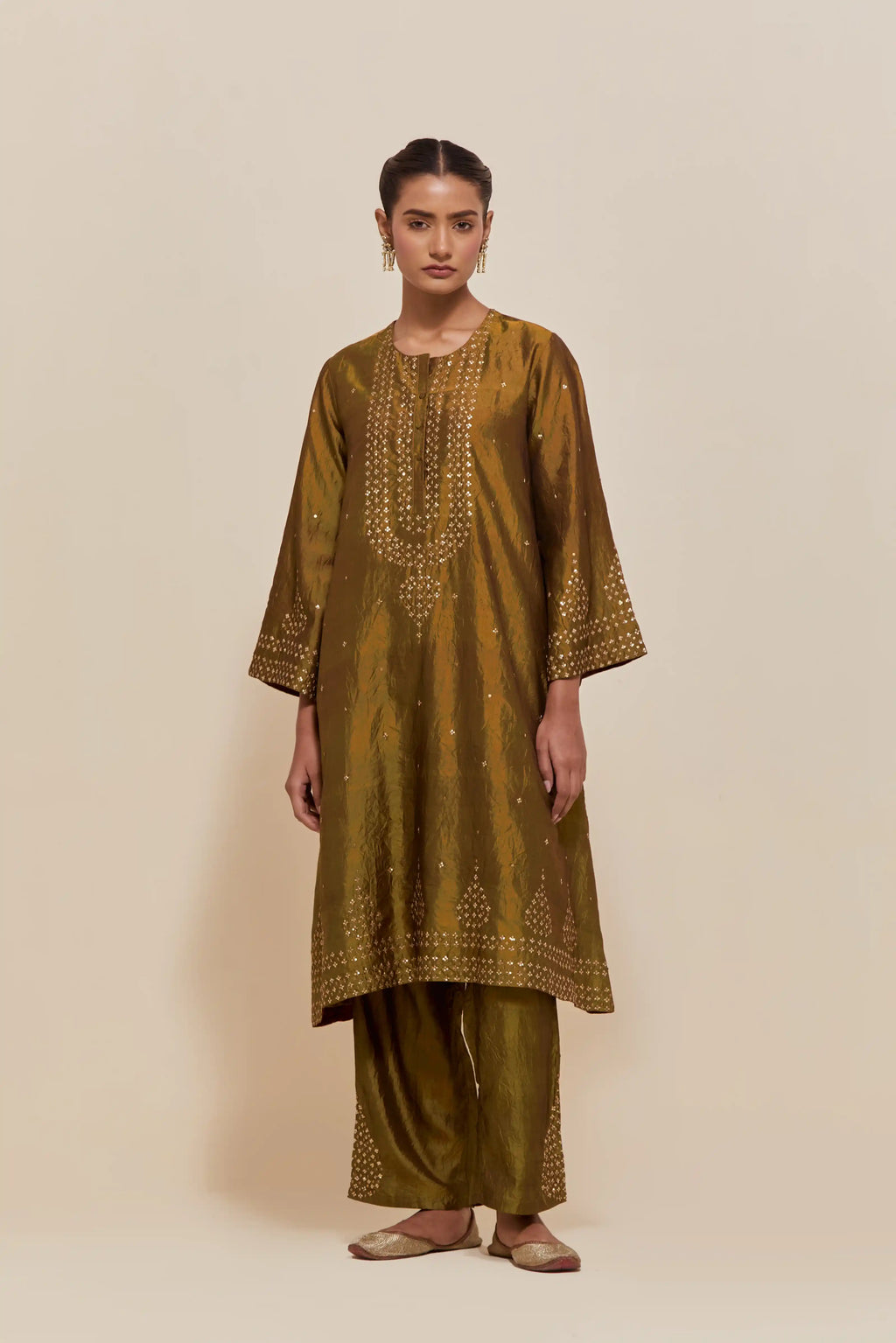 Olive silk A-line short kurta set with hand-embroidered sequins at the neck, borders running along the hem and sleeve edges, and scattered gold sequin embellishments all-over.