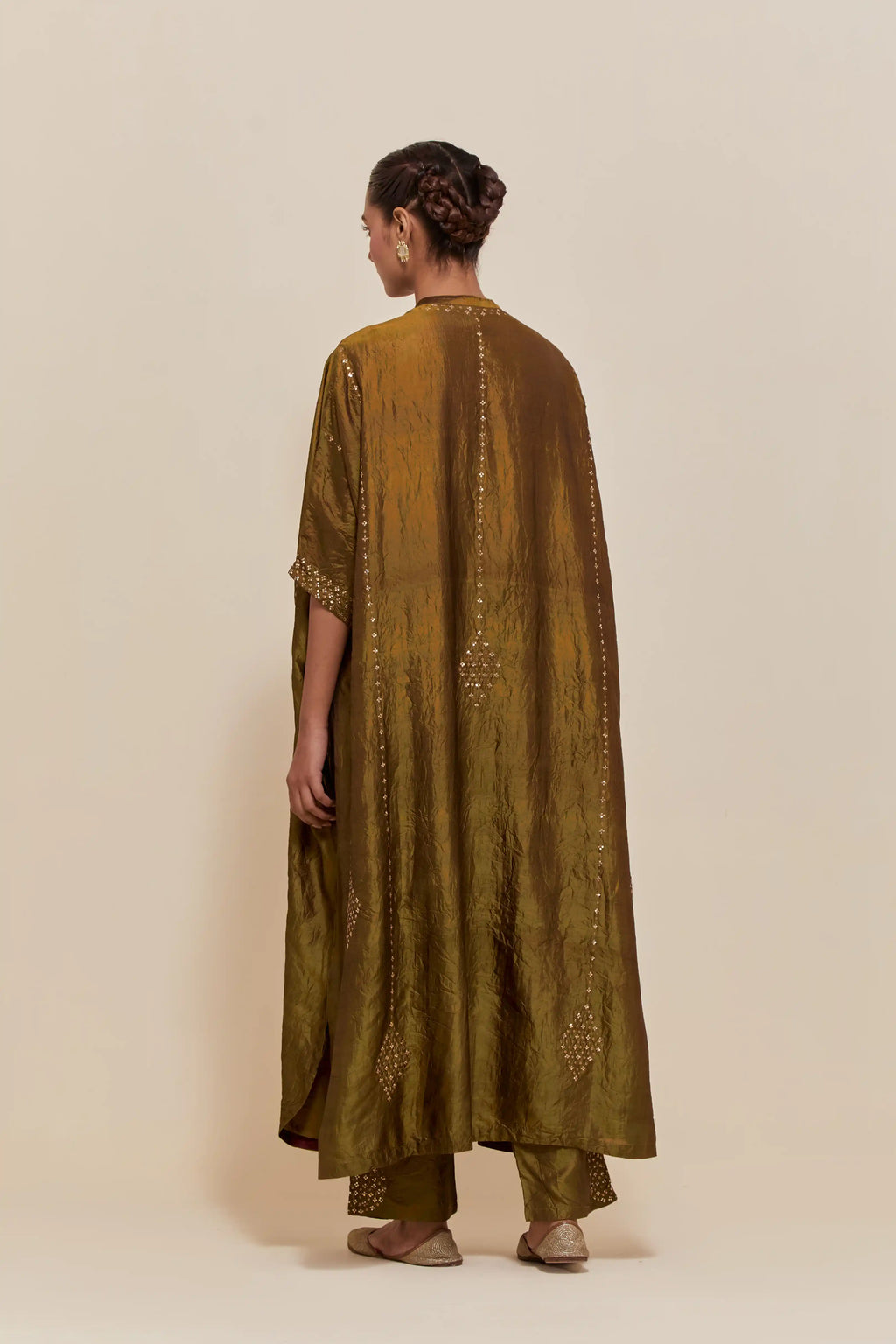 Olive silk long kaftan with hand-embroidered sequins at the neck and diamond motifs along the sides, paired with olive Silk pants with hand embroidered leaf motifs with delicate sequins work at hem.