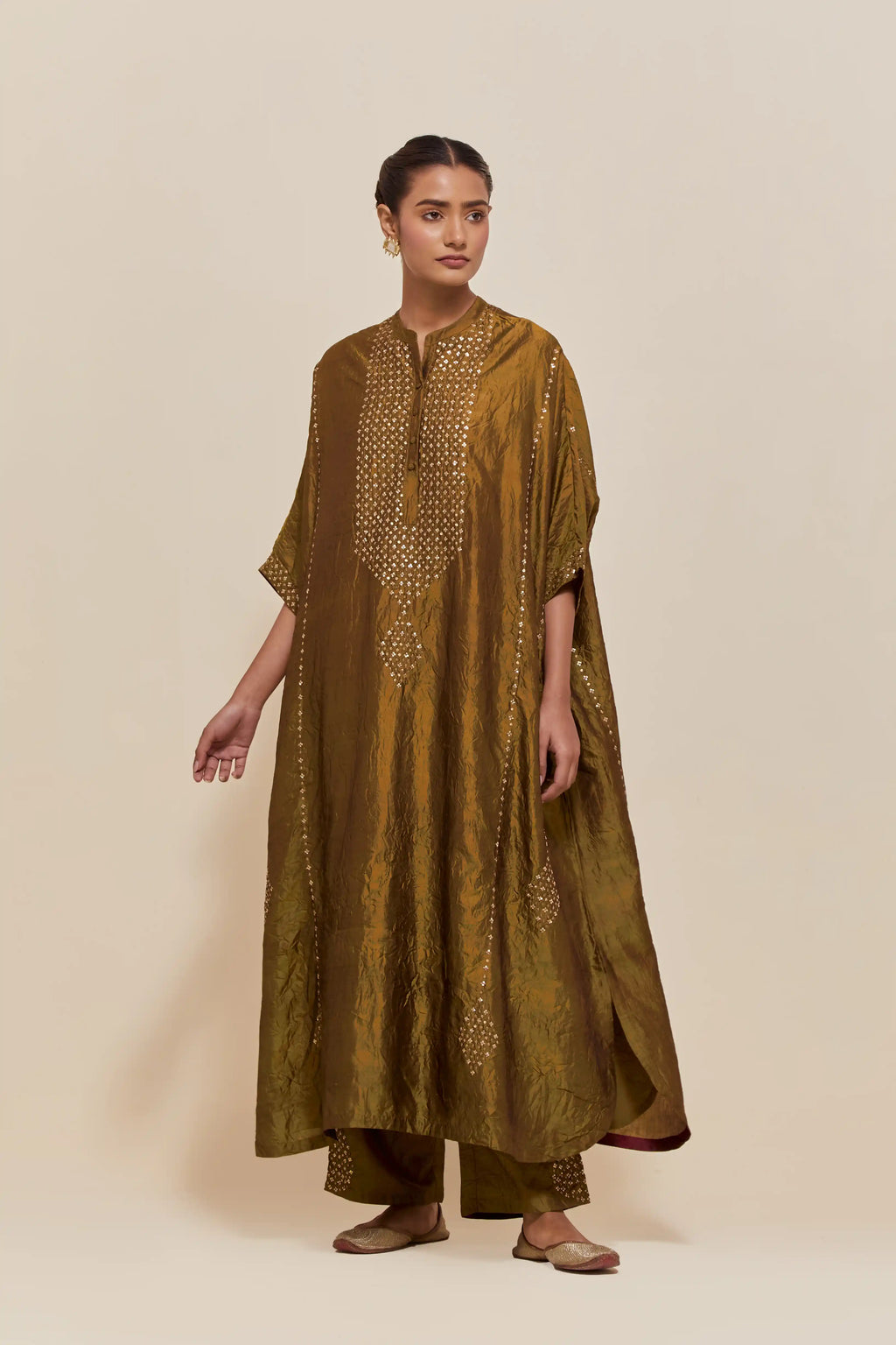Olive silk long kaftan with hand-embroidered sequins at the neck and diamond motifs along the sides, paired with olive Silk pants with hand embroidered leaf motifs with delicate sequins work at hem.