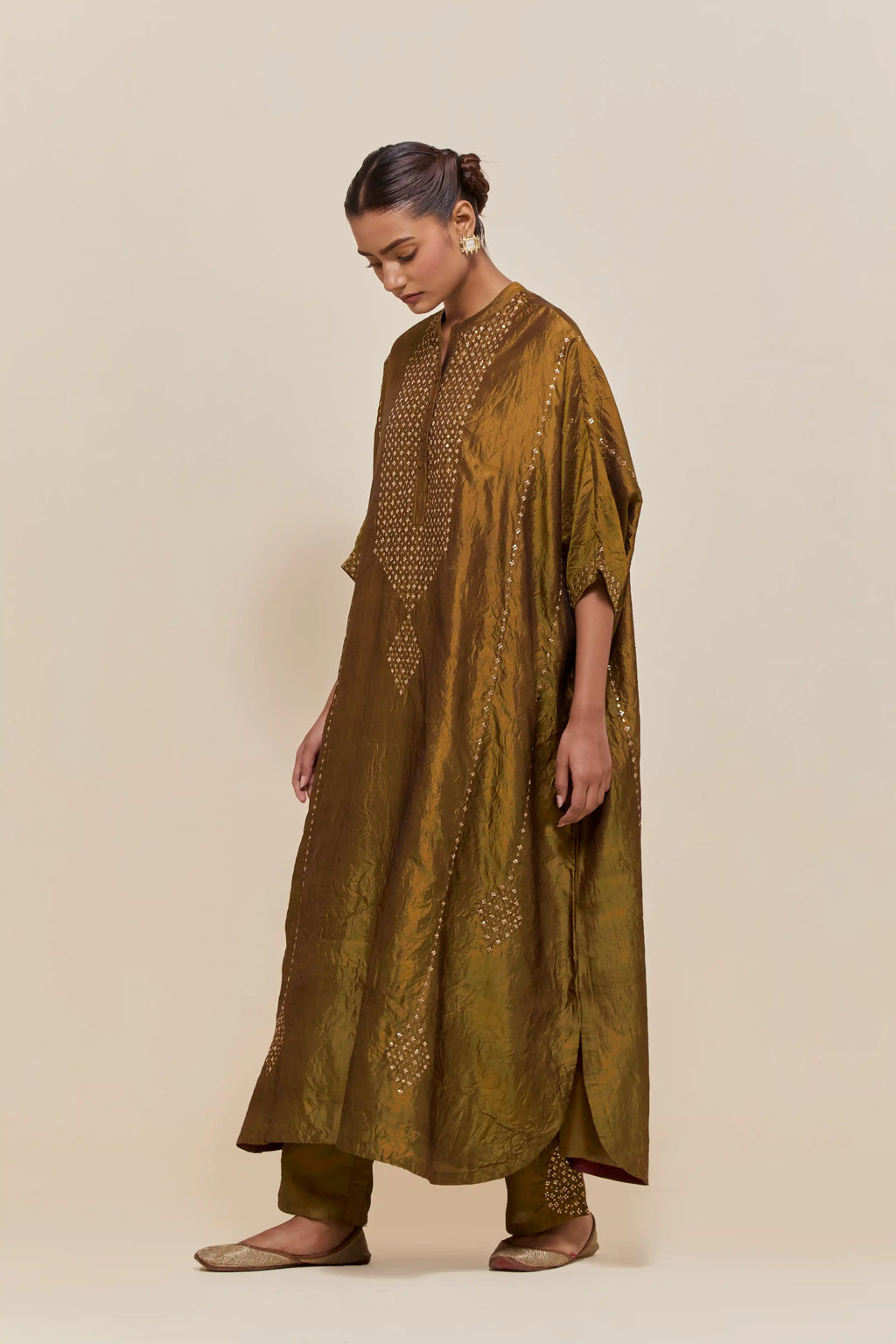 Olive silk long kaftan with hand-embroidered sequins at the neck and diamond motifs along the sides, paired with olive Silk pants with hand embroidered leaf motifs with delicate sequins work at hem.