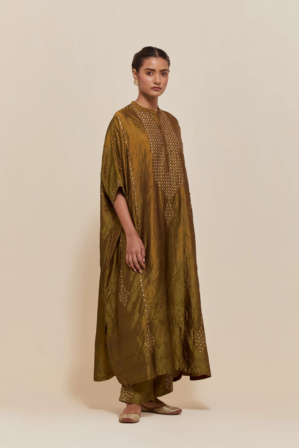Olive silk long kaftan with hand-embroidered sequins at the neck and diamond motifs along the sides, paired with olive Silk pants with hand embroidered leaf motifs with delicate sequins work at hem.