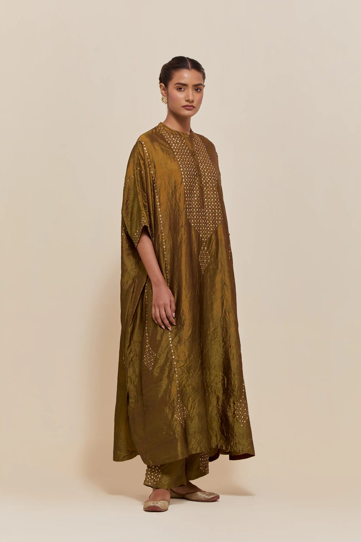 Olive silk long kaftan with hand-embroidered sequins at the neck and diamond motifs along the sides, paired with olive Silk pants with hand embroidered leaf motifs with delicate sequins work at hem.