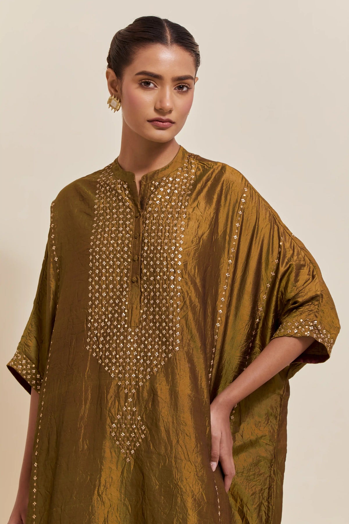 Olive silk long kaftan with hand-embroidered sequins at the neck and diamond motifs along the sides, paired with olive Silk pants with hand embroidered leaf motifs with delicate sequins work at hem.