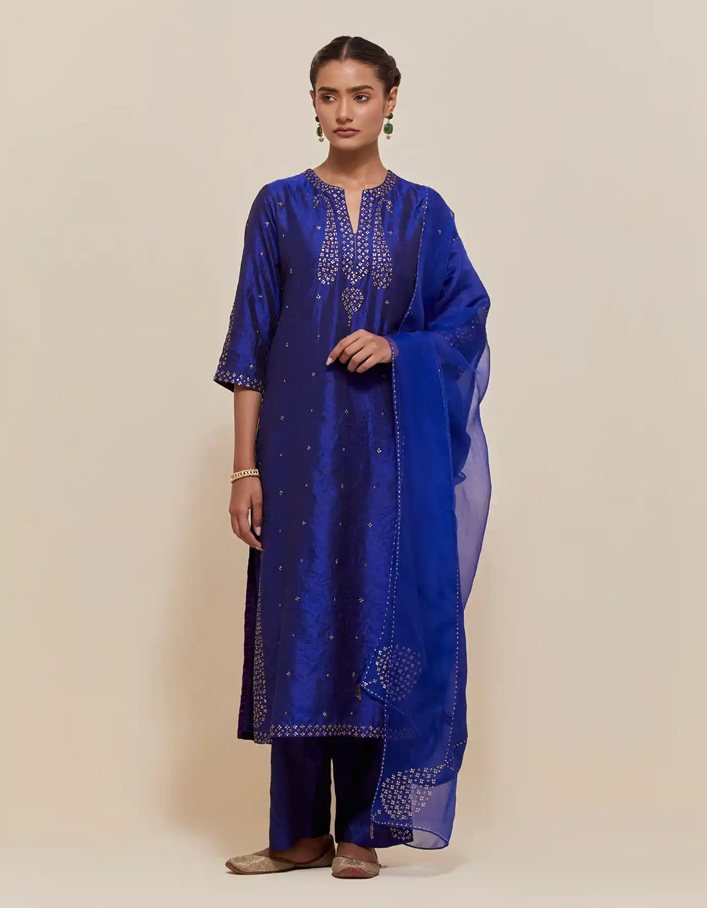 Blue silk straight kurta set with hand-embroidered paisley motifs with delicate gold sequins work at neck, hem, and sleeves, with narrow borders along the edges.