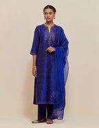 Blue silk straight kurta set with hand-embroidered paisley motifs with delicate gold sequins work at neck, hem, and sleeves, with narrow borders along the edges.