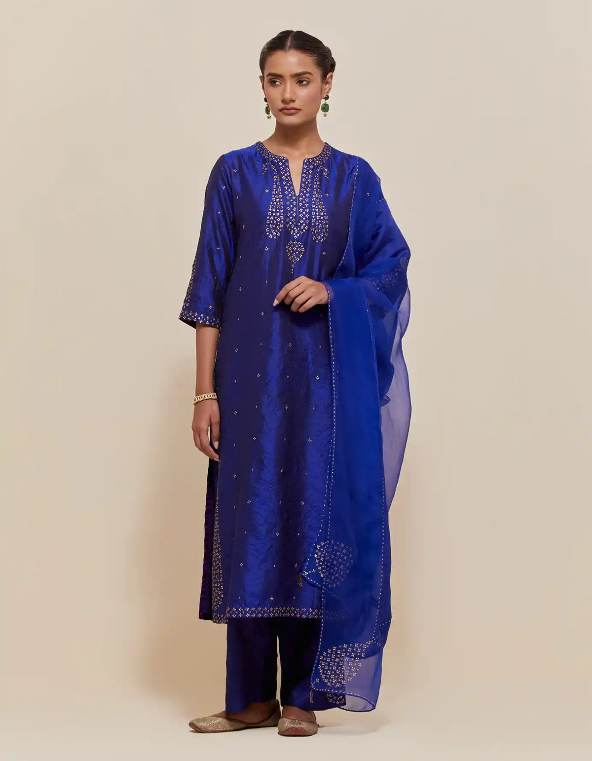 Blue silk straight kurta set with hand-embroidered paisley motifs with delicate gold sequins work at neck, hem, and sleeves, with narrow borders along the edges.