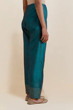 Teal green silk salwar with hand-embroidered gold sequin work in a broad border at the hem.
