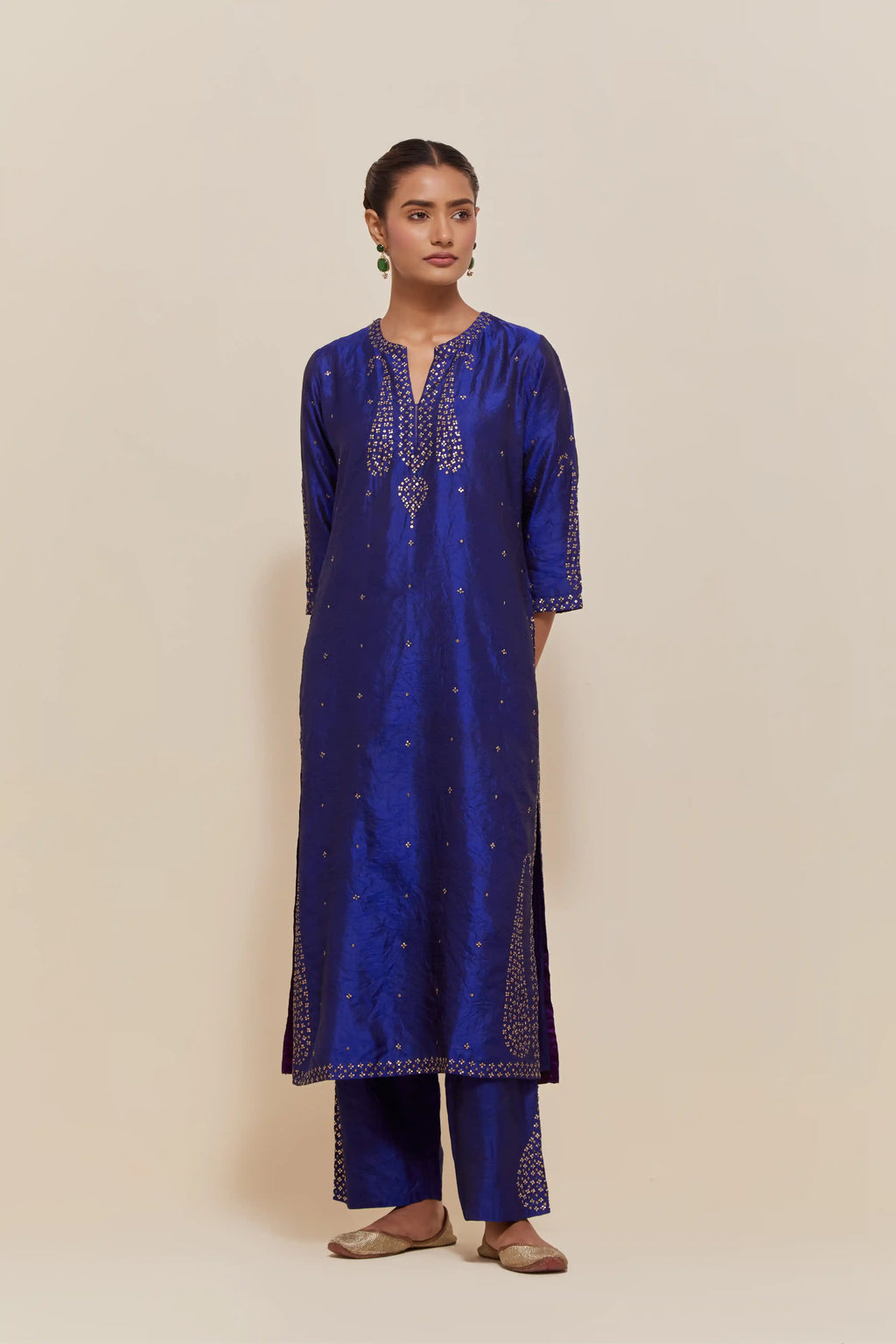 Blue silk straight kurta set with hand-embroidered paisley motifs with delicate gold sequins work at neck, hem, and sleeves, with narrow borders along the edges.