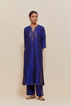 Blue silk straight kurta set with hand-embroidered paisley motifs with delicate gold sequins work at neck, hem, and sleeves, with narrow borders along the edges.