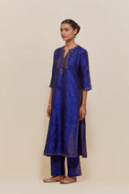 Blue silk straight kurta set with hand-embroidered paisley motifs with delicate gold sequins work at neck, hem, and sleeves, with narrow borders along the edges.