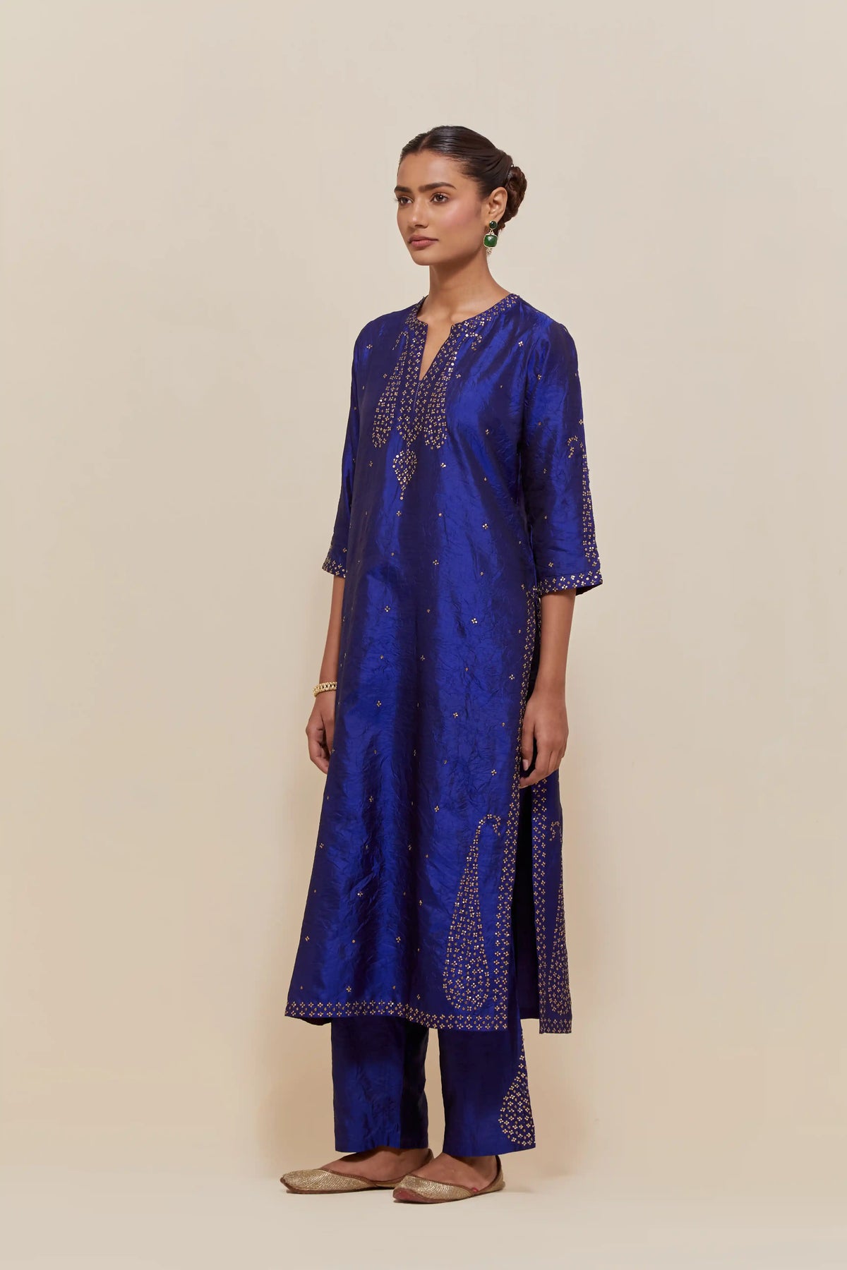 Blue silk straight kurta set with hand-embroidered paisley motifs with delicate gold sequins work at neck, hem, and sleeves, with narrow borders along the edges.