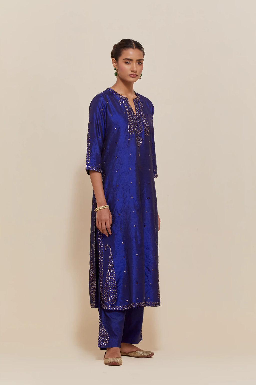 Blue silk straight kurta set with hand-embroidered paisley motifs with delicate gold sequins work at neck, hem, and sleeves, with narrow borders along the edges.