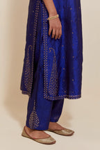 Blue silk straight kurta set with hand-embroidered paisley motifs with delicate gold sequins work at neck, hem, and sleeves, with narrow borders along the edges.