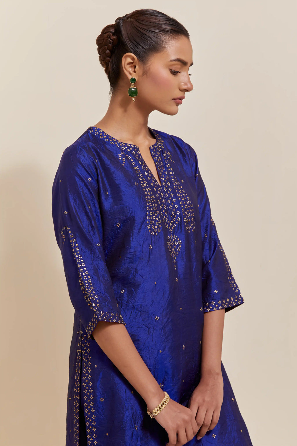 Blue silk straight kurta set with hand-embroidered paisley motifs with delicate gold sequins work at neck, hem, and sleeves, with narrow borders along the edges.