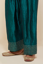 Teal green silk farshi salwar with hand-embroidered gold sequins work in a broad border at the hem.