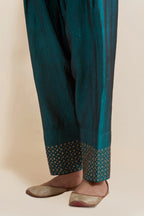 Teal green silk salwar with hand-embroidered gold sequin work in a broad border at the hem.