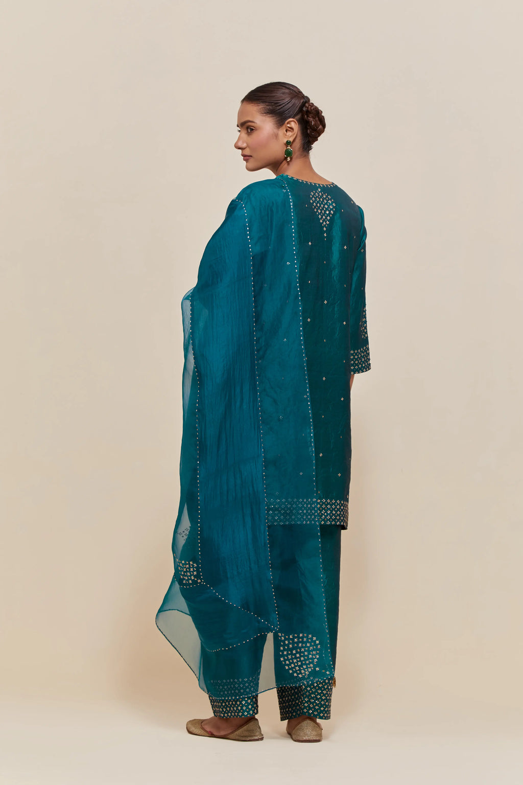 Teal green silk straight short kurta set with hand-embroidered sequins at the neck, borders running along the hem and sleeve edges, and scattered gold sequins embellishments all-over.