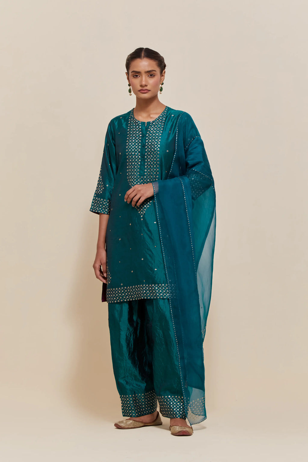 Teal green silk dupatta with silk organza at the sides, highlighted with hand-embroidered gold sequins work.