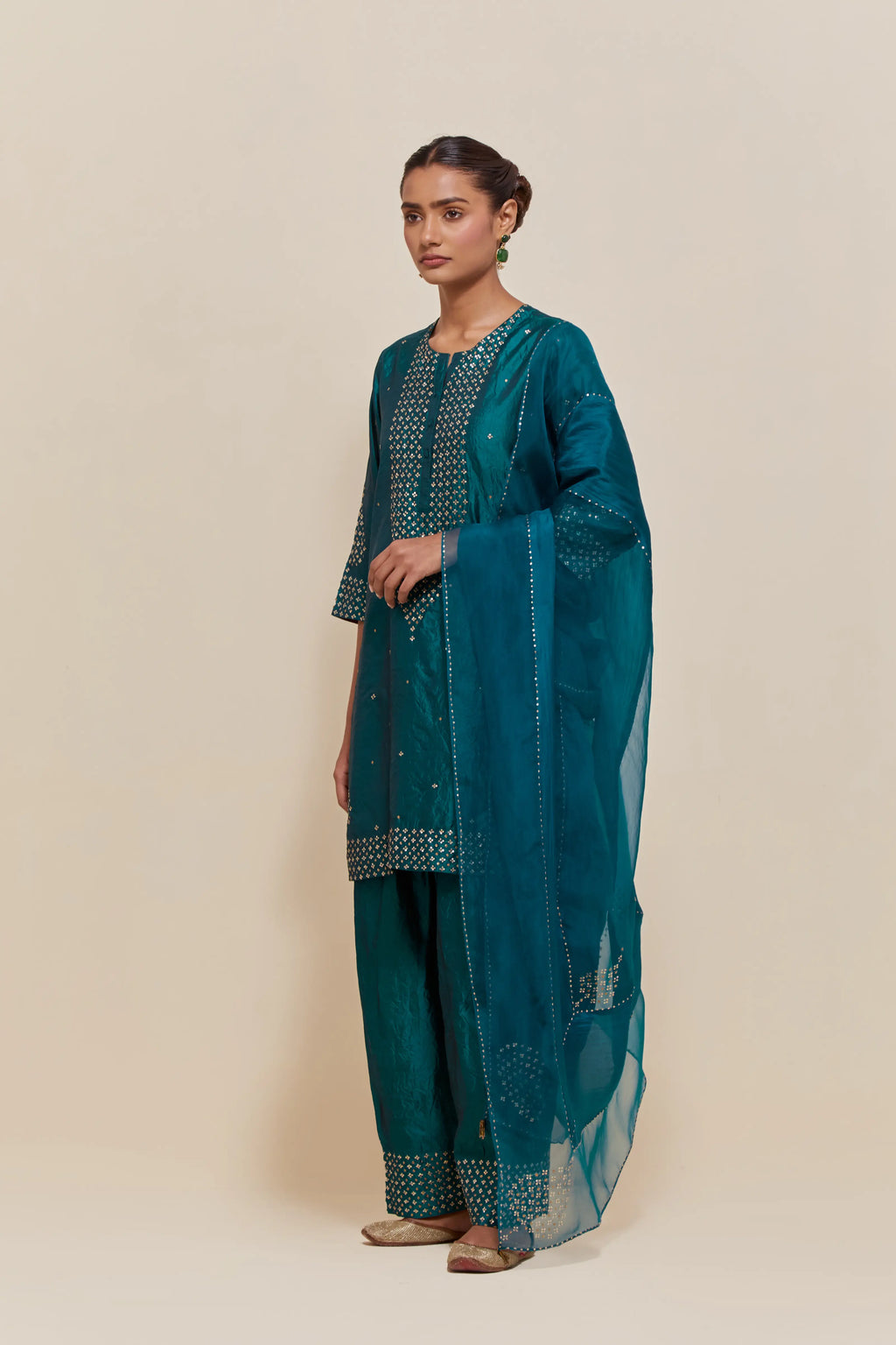 Teal green silk dupatta with silk organza at the sides, highlighted with hand-embroidered gold sequins work.