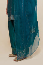 Teal green silk straight short kurta set with hand-embroidered sequins at the neck, borders running along the hem and sleeve edges, and scattered gold sequins embellishments all-over.